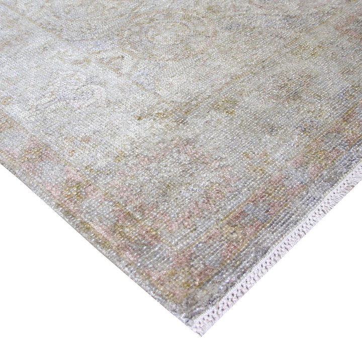 Close-up view of vintage-style woven area rug on white background.