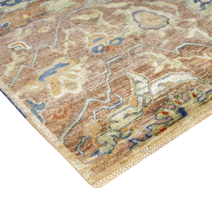 Intricate patterned rug with abstract shapes in beige, brown, blue.