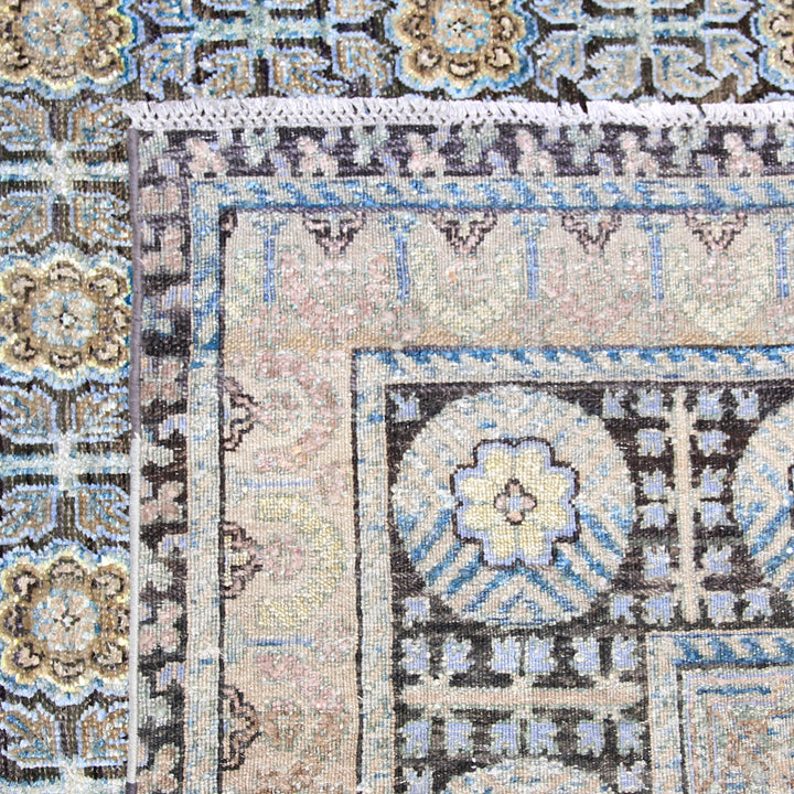 Close-up of intricate Persian-style rug with geometric and floral patterns.