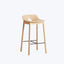 Modern minimalist bar stool with light wood finish and metal footrest.