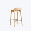 Modern bar stool with light wood finish, minimalist design, footrest.