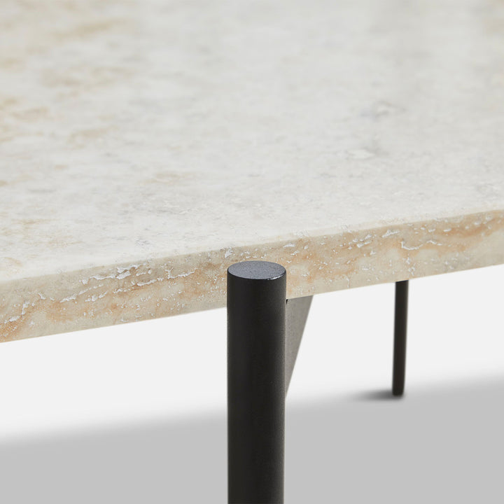 Modern marble table with black metal leg, industrial design aesthetic.