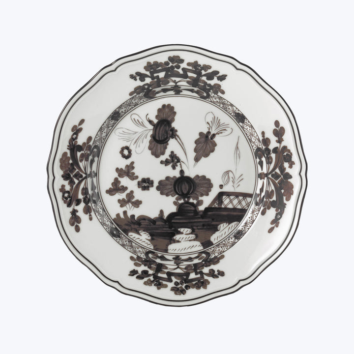 Porcelain plate with intricate floral design and scalloped edge.