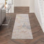 Modern abstract rug on wooden floor with metal console table.