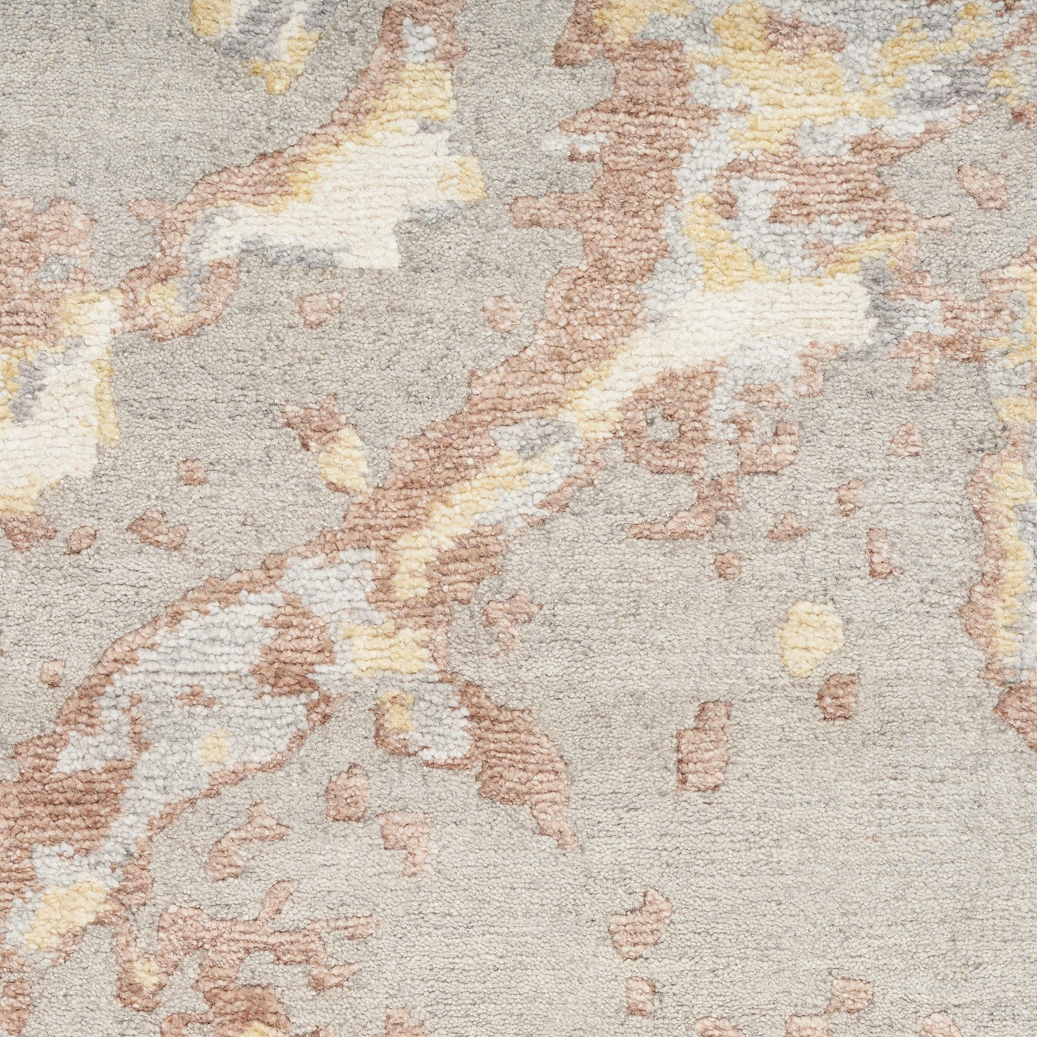 Abstract patterned carpet in earth tones with soft, tactile texture.