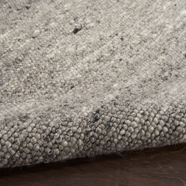 Close-up view of textured rug with looped yarn in neutral colors