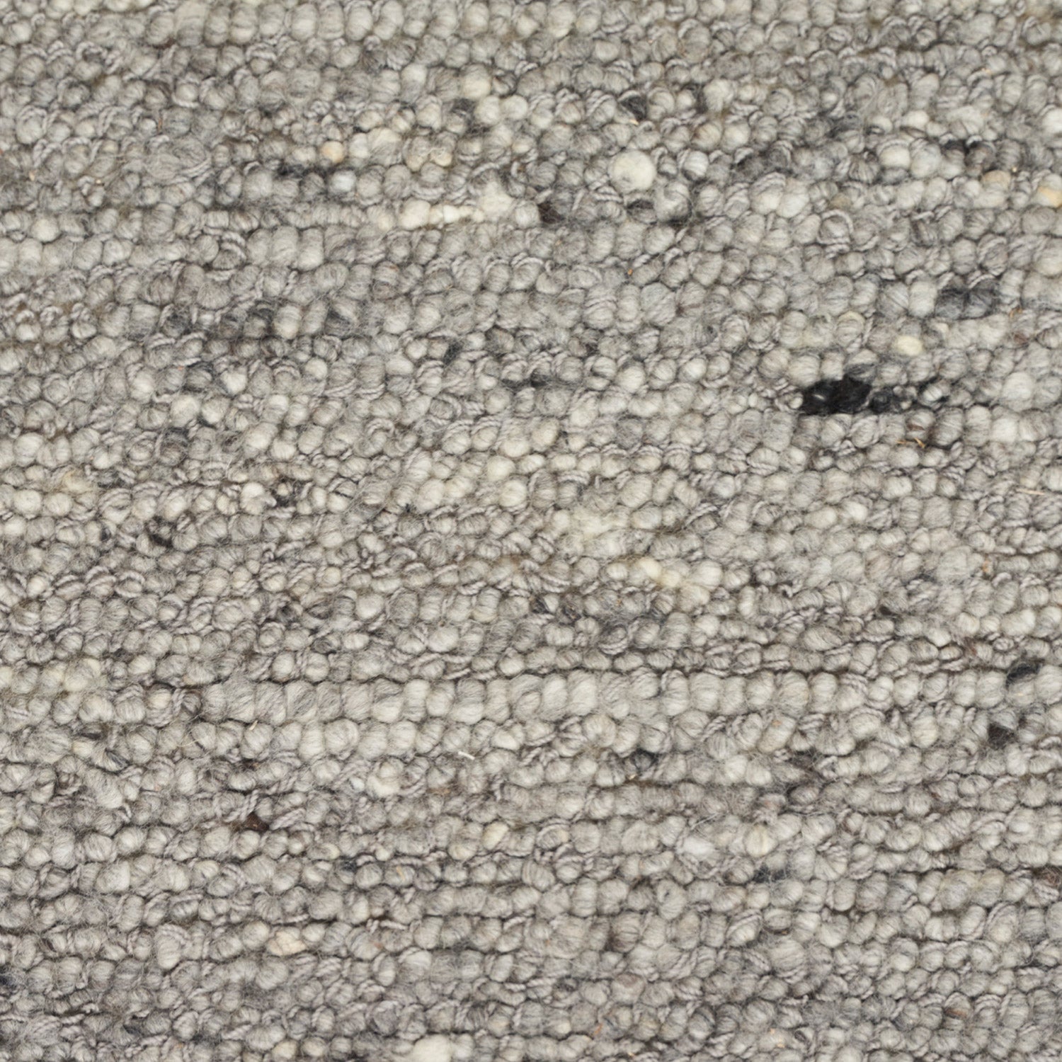 Close-up of loop pile carpet in neutral color with stains.