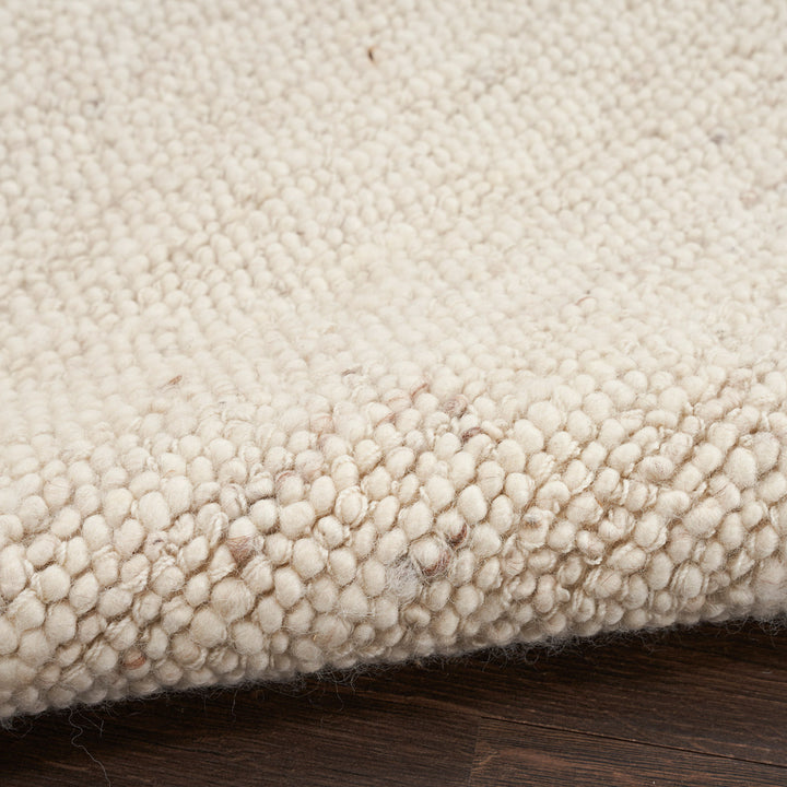 Creamy beige textured rug with raised looped fibers, slight imperfections.