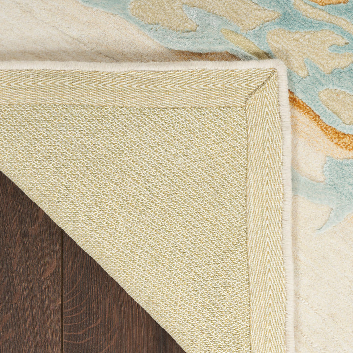 Contrasting rugs overlap on hardwood floor, showcasing different textures and designs.