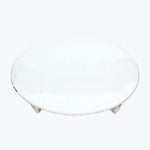 Simple round white ceramic plate with textured surface against white background.