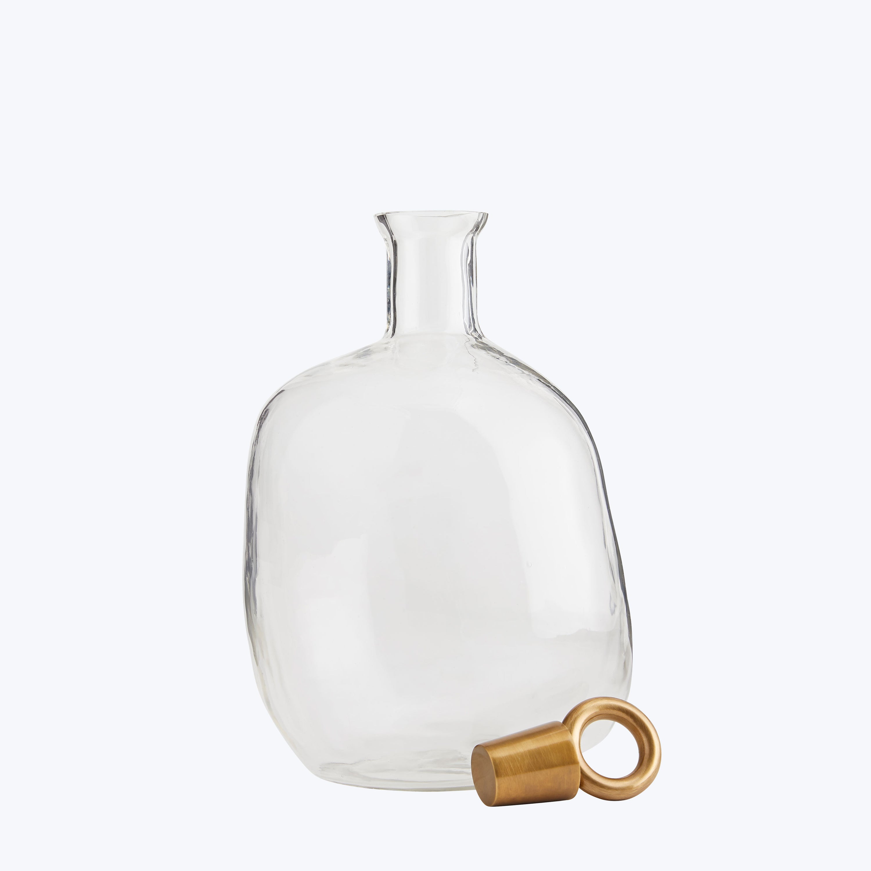 An elegant glass decanter with a golden stopper lying nearby.