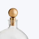 Close-up of a clear glass bottle with gold-colored stopper.