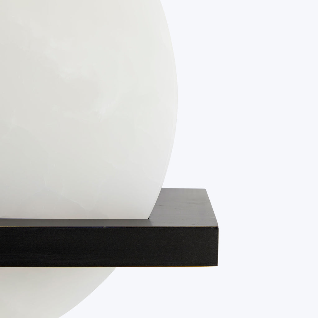 Large, minimalist white sphere rests on sturdy black base.