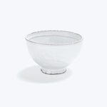Simple white bowl with rustic finish on white background