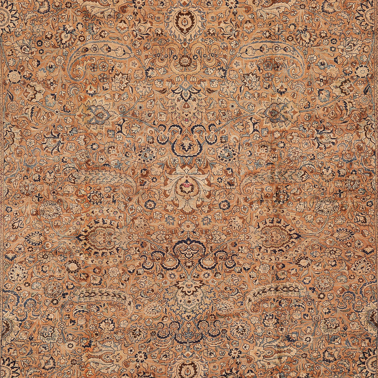 Highly detailed and symmetrical carpet boasting intricate motifs in earth tones.