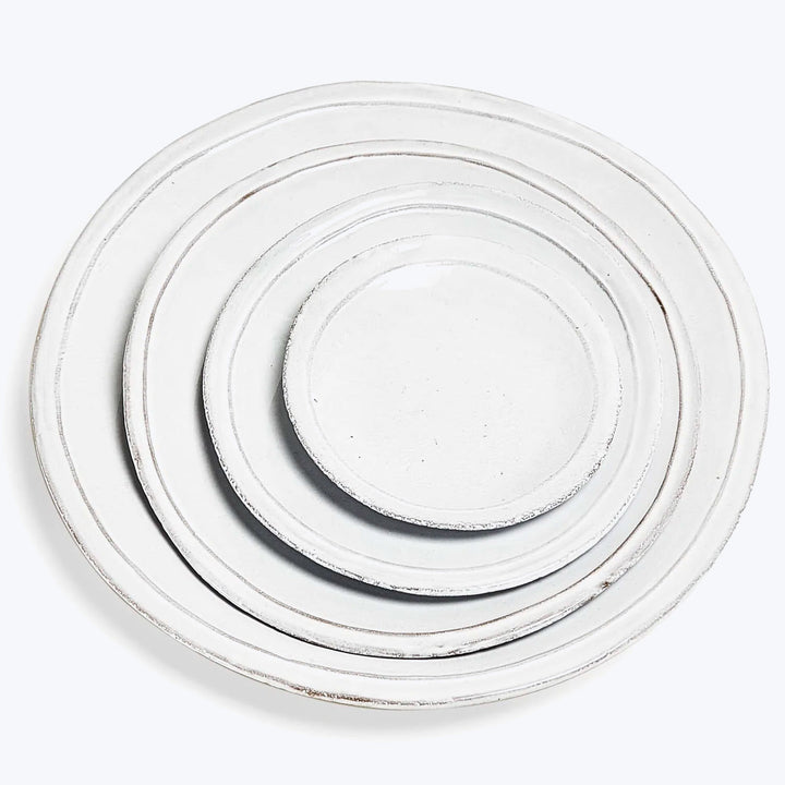 Four white plates stacked in descending order, simple design.