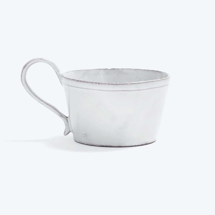 Rustic white mug on white background with slightly distressed look.