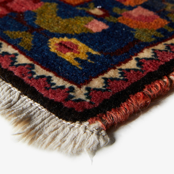 Close-up view of a colorful, intricately patterned handmade wool rug.