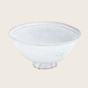 Hand-crafted white textured bowl with footed base on white background.