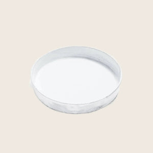 Simple white ceramic plate on white background, top-down view.