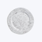 Decorative white ceramic plate with embossed botanical illustrations.
