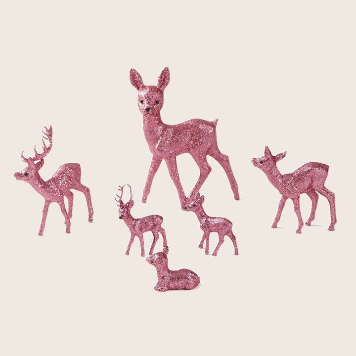 Six sparkly pink deer figurines in various poses on display.
