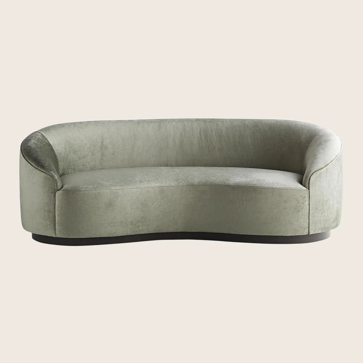 Contemporary green velvet sofa with sleek silhouette and luxurious feel.