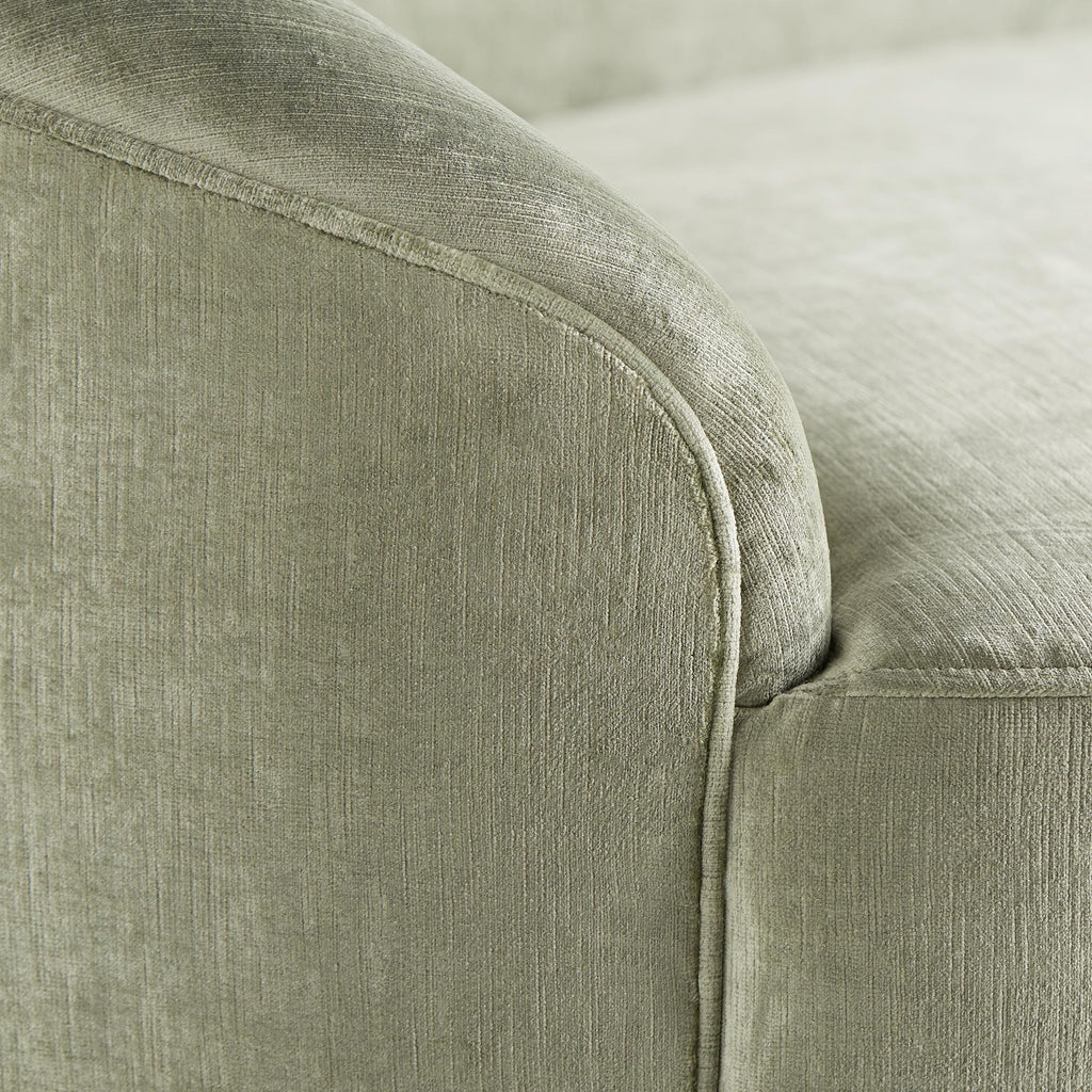 Close-up detail of upholstered furniture in light green/grey fabric.