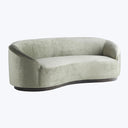 Modern-style curved sofa upholstered in soft, pale green velvet fabric