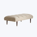 Modern upholstered bench with curvilinear design and wooden legs.