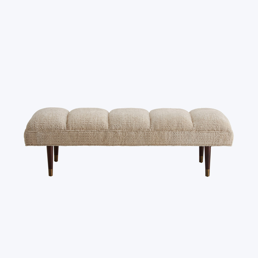 Modern style bench with tufted cushioned segments and wooden legs.