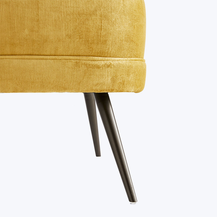 Close-up of modern mustard yellow chair with sleek angled legs.
