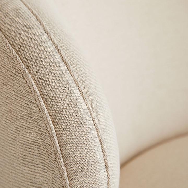 Close-up of textured beige fabric with prominent weave pattern and seam detail.