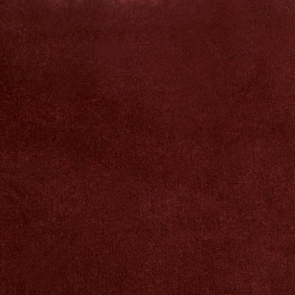 Close-up of maroon velvet fabric with a luxurious, plush texture.