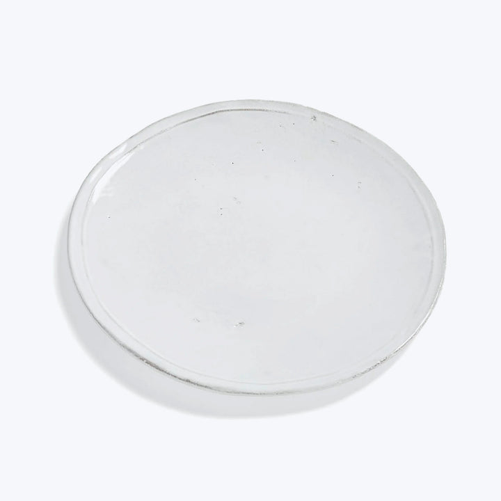 Clear petri dish with minor imperfections on plain white background.