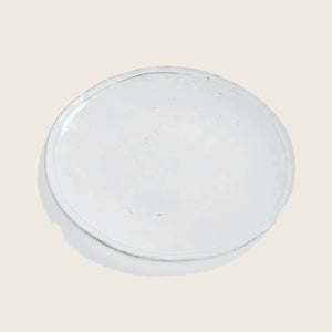 Clear petri dish with minor imperfections on plain white background.