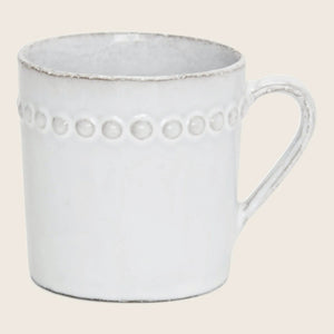 Rustic ceramic mug with raised dotted pattern and comfortable handle.