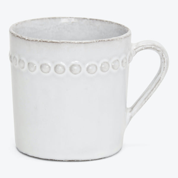 Rustic ceramic mug with raised dotted pattern and comfortable handle.
