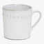 Rustic ceramic mug with raised dotted pattern and comfortable handle.