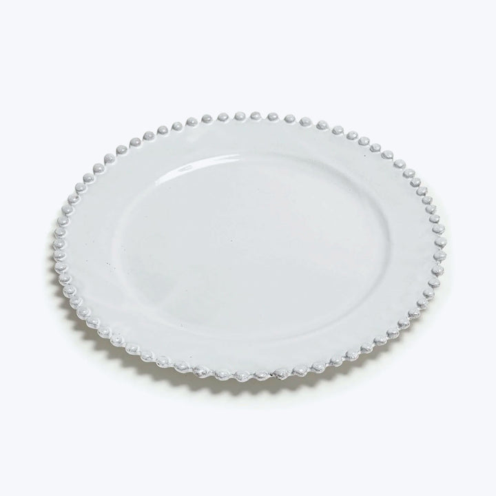 Elegant white plate with textured edge design on white background.