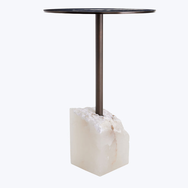 Contemporary table with dark round top and raw stone base.