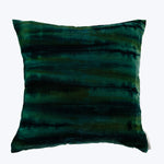 Tie-dye square pillow in dark green and blue hues.