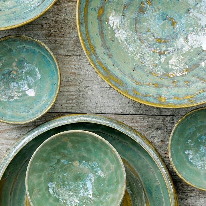 Handcrafted ceramic dishes with marbled glaze in vibrant blue-green tones.