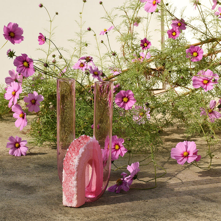 Modern artistic composition with glass cylinders, crystalline arch, and flowers