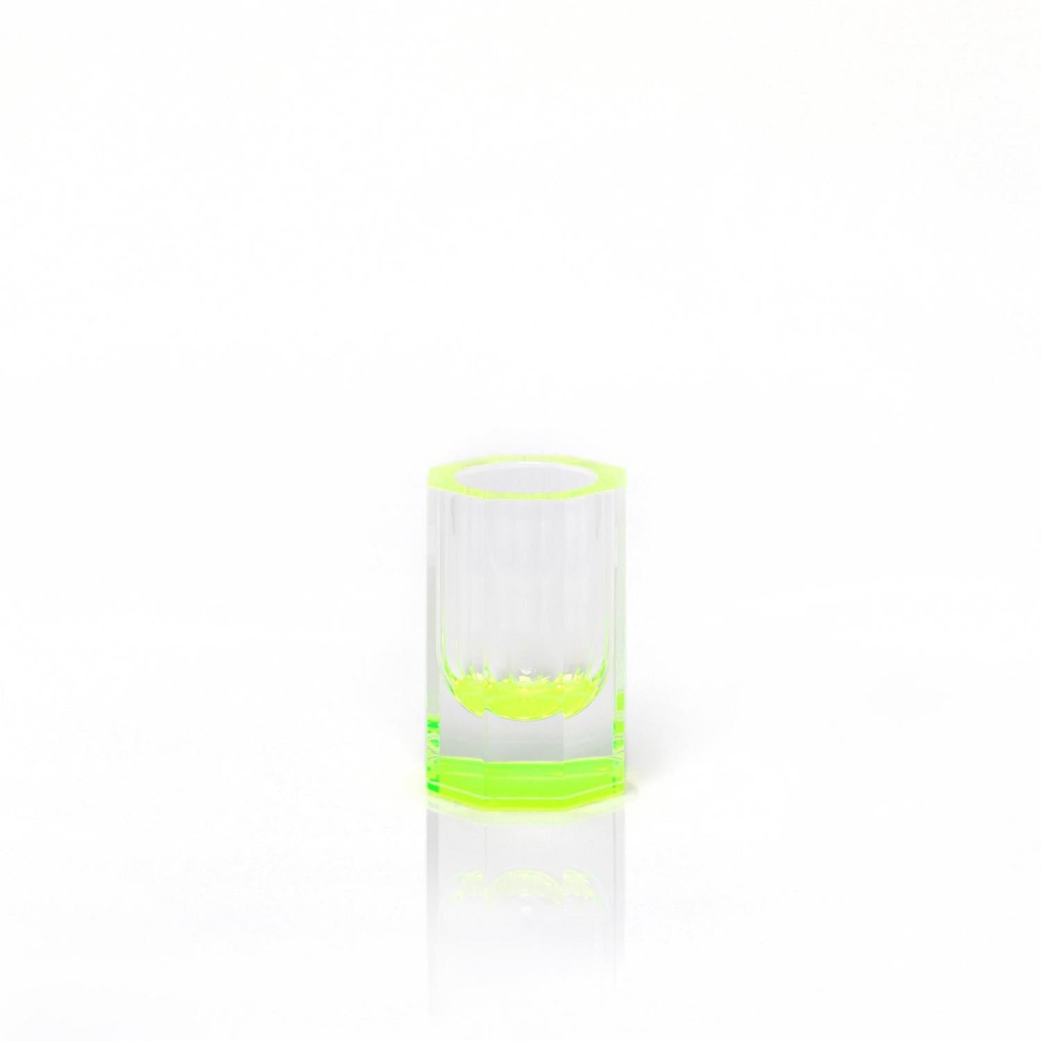 Minimalist glass with neon green accents on reflective surface.