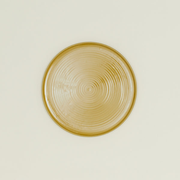 An elegant golden dish with a concentric circular pattern.