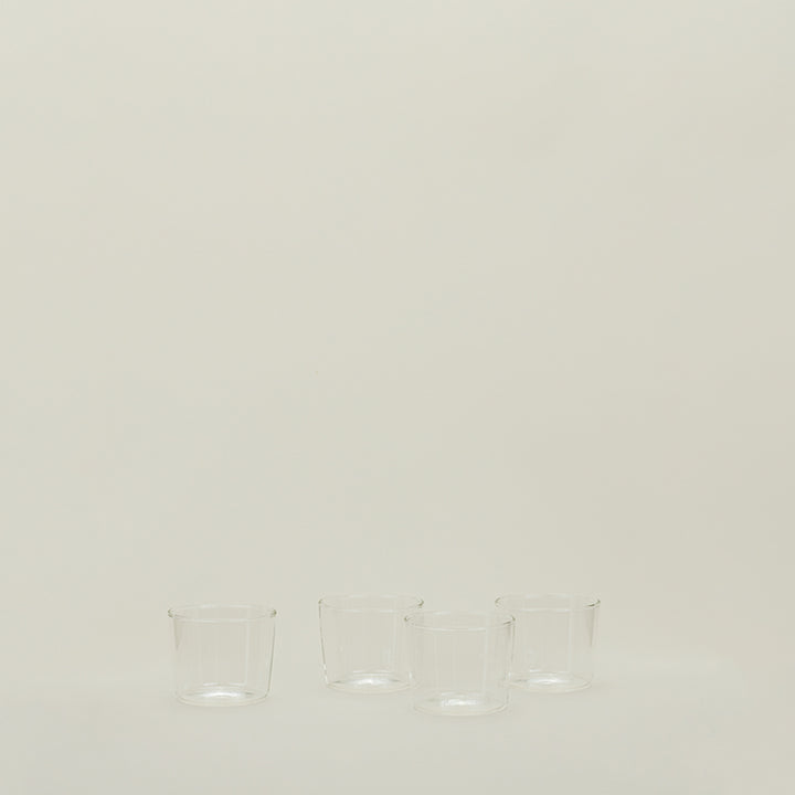 Minimalist arrangement of empty glass cups on neutral background.
