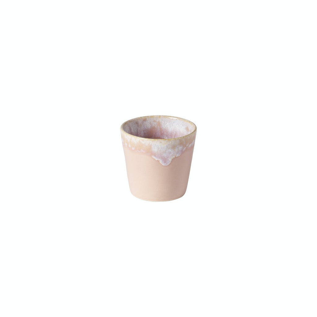 Used paper cup with dried frothy residue on beige background.
