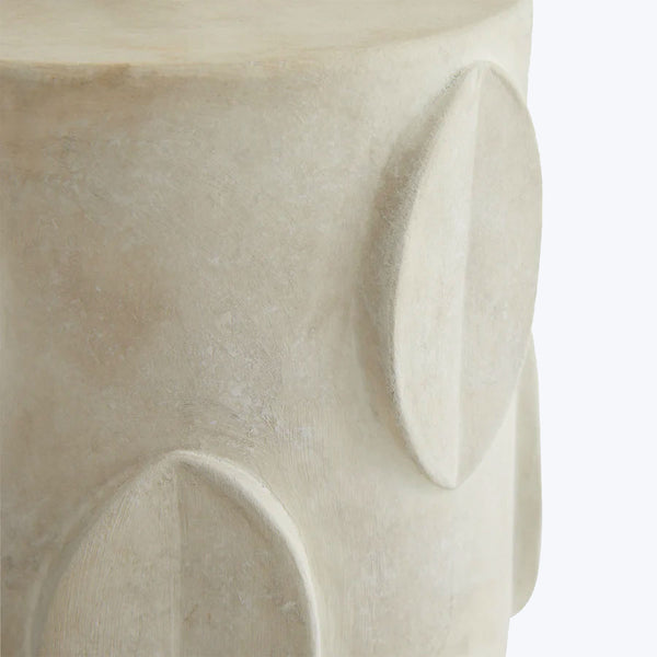Close-up of a smooth, cream-colored wooden object with embossed geometric patterns.