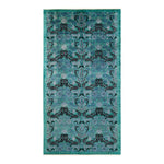 Intricate symmetrical floral patterned area rug with teal background.